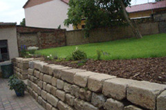Bau einer Trockenmauer aus alten rustikalen Granitbordsteinen